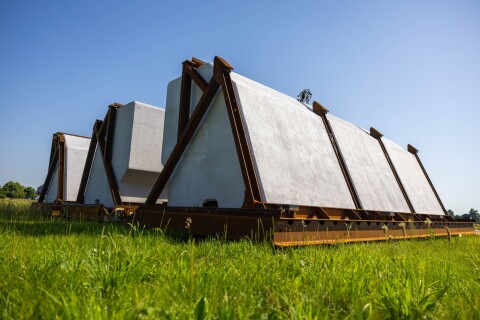 Coated EPS flood barrier segments with AllShield CoreShield, lined up in a field and ready for installation in Arcen.